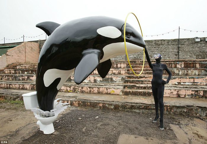 Sculpture showing killer whale jumping out of toilet at Banksy's Dismaland